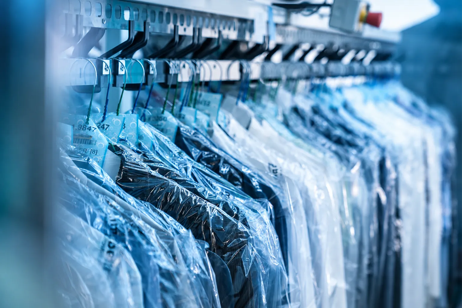 Gereinigte Kleidung hängt geschützt auf einer Kleiderstange