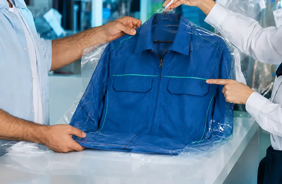 Mitarbeiter prüft eine blaue Jacke für ein Reinigungsangebot in Fellbach
